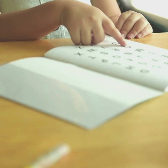 A little girl reading the alphabet