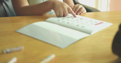 A little girl reading the alphabet