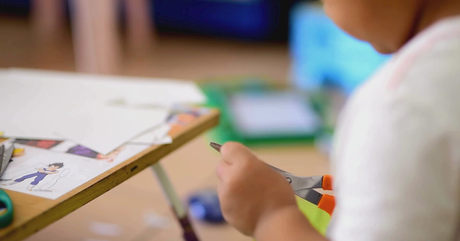 A child carefully cutting out shapes and pieces on the cut-out pages of KidzzyLab busy book