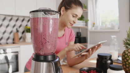 A mother using the ebook on a tablet while preparing baby food in the kitchen.