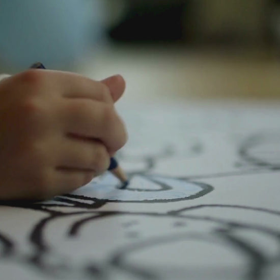 A child is coloring  animals on coloring Book of KidzzyLab brand