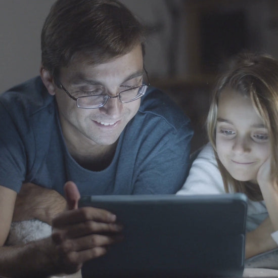 A father and his daughter are reading the story Lina and Toto's Adventure by KidzzyLab.